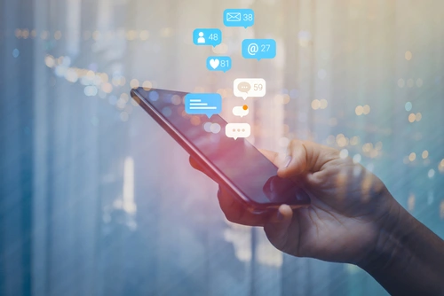 image of a hand holding a cell phone with social media likes and posts popping out of the phone, Attorney ethical considerations on social media