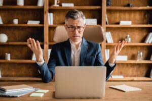 Frustrated attorney reviewing declining Google Ads metrics and wasted PPC budget on laptop in law office