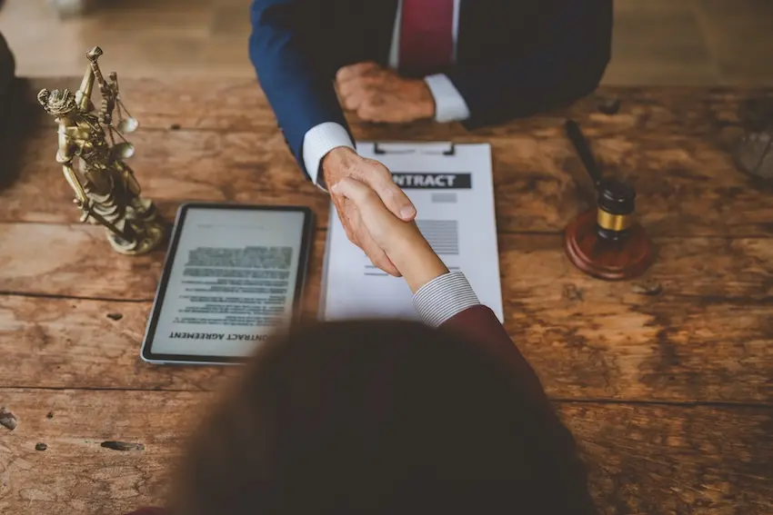 Attorney and client completing a signed retainer agreement following a successful intake consultation