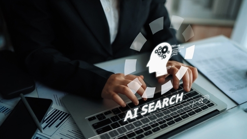 A lawyer at his desk looking up AI search on his computer represents AI optimization for law firms.